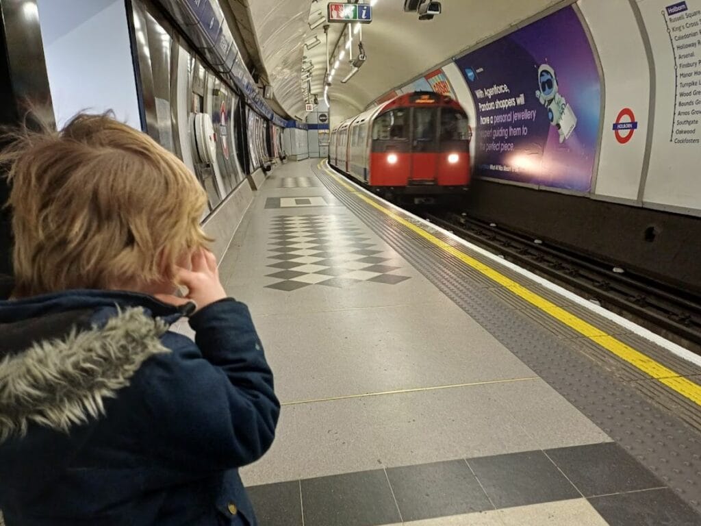 Oliver watching a train arrive at Holborn Underground Station.